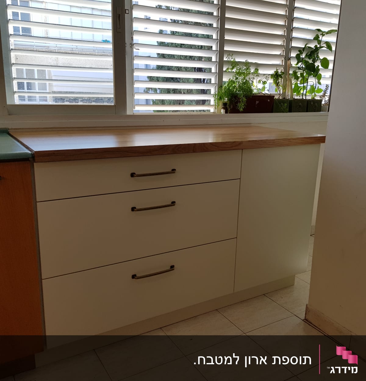 ארונות מטבח עם ידיות מתכת ומשטח עץ